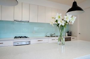 Kitchen installation with a blue glass splashback
